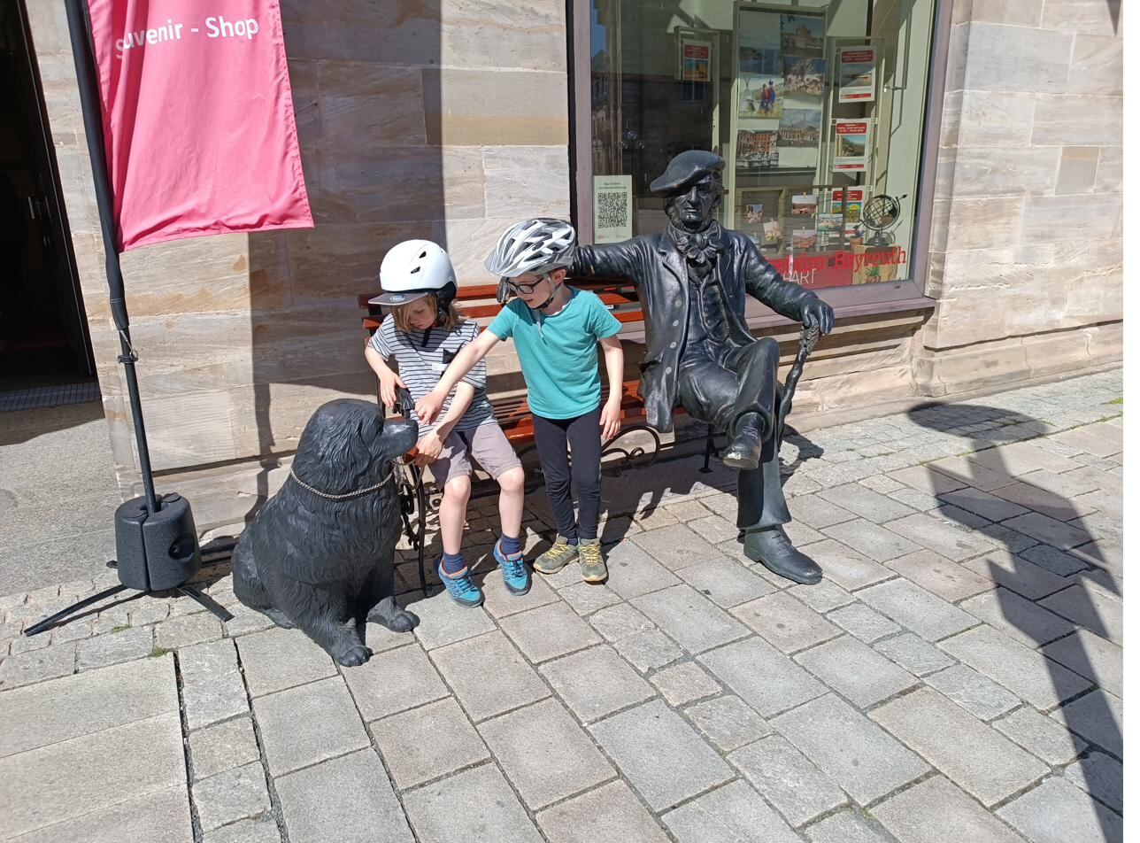 Fahrrad lehnt bei einer Radfahrpause an einer Richard-Wagner-Wand in Bayreuth